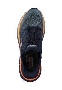 Sneaker color blu navy con parte superiore in tessuto testurizzato, dettagli arancioni, lacci frontali e suola interna ammortizzata etichettata "Skechers Slip-ins."