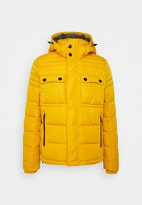 Žlutá péřová bunda s kapucí, s prošívanými horizontálními liniemi, dvěma kapsami na prsou, dvěma bočními zipy a černými knoflíkovými detaily.