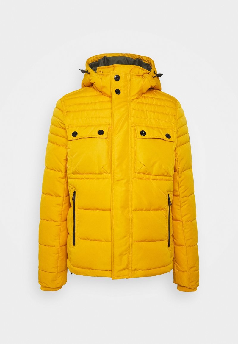Žlutá péřová bunda s kapucí, s prošívanými horizontálními liniemi, dvěma kapsami na prsou, dvěma bočními zipy a černými knoflíkovými detaily.