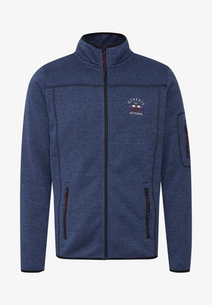 Blå fleecejakke med høy krage, hel glidelås, to sidelommer og en lomme på venstre erme. Har røde og svarte detaljer.