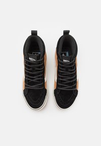 Adidași înalți cu un amestec de suede negru și maro. Prezintă șireturi gri, o dunga albă pe lateral și un guler căptușit pentru confort.