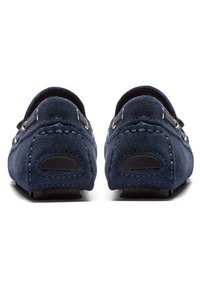 Tmavě modré semišové mokasíny s kontrastním šitím, zaobleným tvarem zadní části a pryžovými přizdobenými podrážkami pro lepší přilnavost.