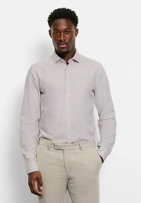 Striped dress shirt in light beige with a button-down collar, long sleeves, and a smooth textile. Paired with light-colored trousers.