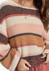 Gestrickter Pullover mit breiten horizontalen Streifen in den Farbtönen Pink, Burgund, Braun und Creme; lockere Passform mit geripptem Saum und Bündchen.