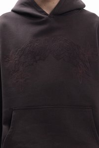 Crna majica s kapuljačom s teksturiranim, toniranim vezom s detaljnim uzorcima na prsima i prednjim džepom.