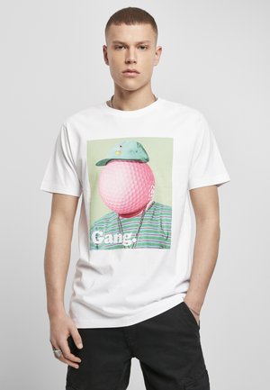 Weißes T-Shirt mit einem grafischen Motiv eines rosa Golfballs als Kopf, der eine hellblaue Kappe trägt, vor einem Hintergrund mit grünen und blauen Streifen. Darunter steht "Gang".