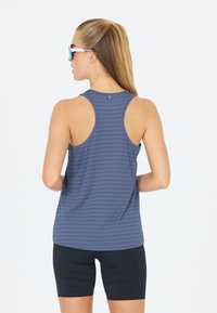 Mouwloze sporttop in marineblauw met horizontale strepen, gecombineerd met zwarte shorts. Glad textuur en racerback ontwerp, met een eenvoudig logo.