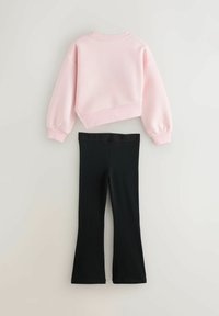 Felpa rosa corta con maniche lunghe, abbinata a leggings neri a campana con una fascia elastica nera e la scritta "BAKE".