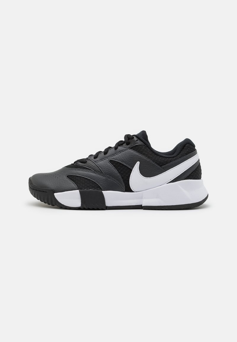 Pantofi sport negri cu un upper texturat, accente albe, talpă din cauciuc negru și un logo Nike swoosh alb contrastant pe partea laterală.