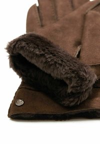 Braune Wildlederhandschuhe mit einem dicken, weichen Futter aus Fell am Bund. Mit einem silbernen Logo-Detail am Handgelenk.