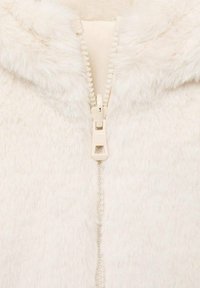 Sudadera con capucha de piel sintética con cremallera en color crema, que presenta una textura suave, cremallera central con una lengüeta blanca y forro interior.