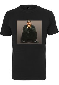Sort bomulds T-shirt med et grafisk tryk af en person, der squatter med hænderne foran ansigtet, sat mod en gradient baggrund. Korte ærmer.