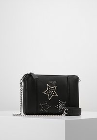 Svart syntetisk handväska med silverkedjeaxelrem, prydd med stjärnmönster dekorerade med rhinestones och en logotyp präglad på framsidan.