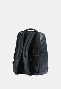 Zaino in pelle blu navy con spallacci imbottiti e regolabili e un pannello in tessuto nero testurizzato. Dispone di un manico superiore e tasche laterali.