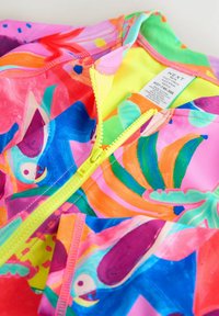 Farebné plavky s tropickým vzorom v odtieňoch ružovej, modrej a zelenej. Majú fluorescenčný žltý zips a hladkú textúru.