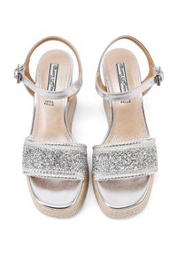Sandali platform in argento con tomaia lucida e cinturino glitterato. Dettagli notevoli: cinturino alla caviglia, suola testurizzata e banda frontale larga.