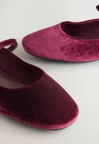 Bordowe aksamitne baleriny z okrągłym noskiem, cienkim paskiem na wierzchu stopy i gładką teksturą. Gumowa podeszwa, prosty design.