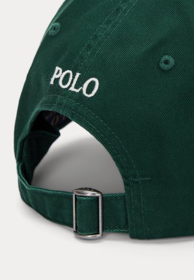 Grön bomullsmössa med justerbar metallspänne. "POLO" broderat i vitt på baksidan. Texturerad tyg med sydda detaljer.