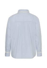 Chemise bleu clair à manches longues avec bordure en dentelle sur le col et les poignets, vue de dos.