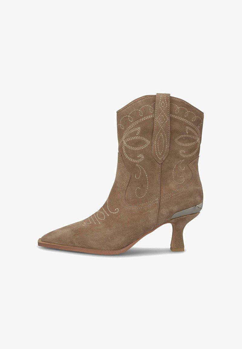 Stivaletto alla caviglia in suede marrone con ricami leggeri intricati, punta appuntita e dettaglio di tacco curvo in metallo. Include un linguetta per una facile indossatura.