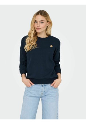 Sweatshirt bleu marine avec des poignets et un ourlet côtelés, arborant une petite icône d'ours doré sur la poitrine gauche. Tissu doux et décontracté.