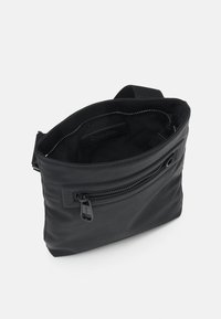 Borsa a tracolla nera con texture liscia, compartimento principale con zip, tasca esterna con zip e fodera interna brandizzata. Include una tracolla regolabile.