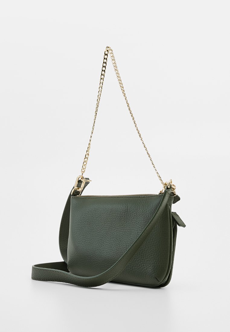 Dunkelgrüne, strukturierte Leder-Crossbody-Tasche mit goldener Kettenriemen und zusätzlichem Ledertragegurt, vor einem schlichten, hellen Hintergrund gezeigt.