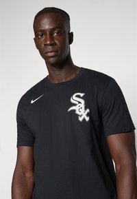 Camiseta de algodón negra con un logo bordado en blanco "Sox" en el lado izquierdo del pecho. Diseño de manga corta y cuello redondo con una textura suave.