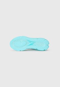 Sneaker sål i lyseblå gummi, med buede mønstre, riller for greb og en afrundet form for komfort og støtte.