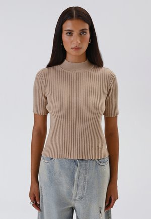Beige ribbed knit short-sleeve top with a high collar and a slightly cropped hem, featuring an embroidered logo on the lower side.
