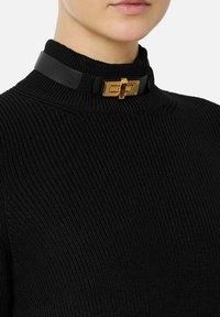 Maglione nero a costine con collo alto, impreziosito da una fascia in pelle nera e un dettaglio in metallo dorato con fibbia al collo.