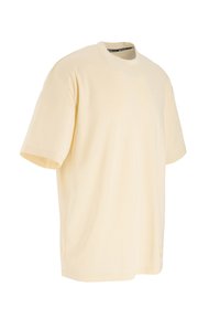 Light yellow oversized cotton t-shirt with a crew neckline, short sleeves, and minimal detailing on the lower side. Soft texture.