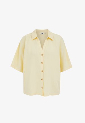 Chemise jaune pâle à manches courtes avec col et cinq boutons sur le devant, présentée sur fond blanc.