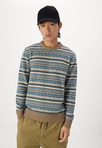 Suéter de punto con un patrón geométrico en azul, beige y crema. Cuello redondo con puntada acanalada y dobladillo, con mangas largas y un corte relajado.