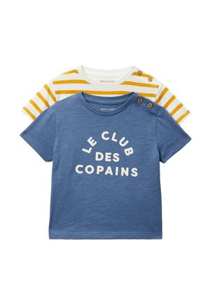Deux t-shirts pour tout-petits, un bleu avec le texte « Le Club Des Copains » et des boutons sur l'épaule, l'autre blanc avec des rayures jaunes et des boutons à l'épaule.
