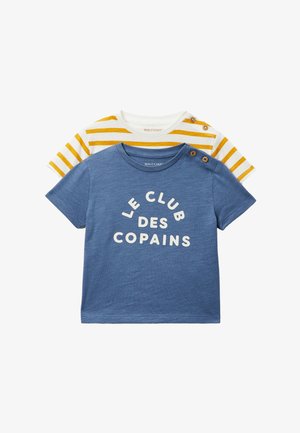 Deux t-shirts pour tout-petits, un bleu avec le texte « Le Club Des Copains » et des boutons sur l'épaule, l'autre blanc avec des rayures jaunes et des boutons à l'épaule.