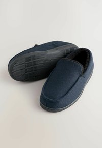 Marineblauwe slippers met een zachte textielen bovenkant, een fuzzy voering en een rubberen zool. Gladde textuur met een ronde neus en minimale stikdetails.