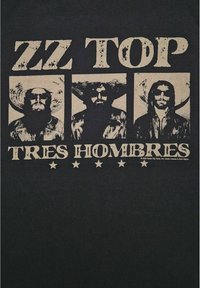 Černé tričko s vintage designem, na kterém jsou tři obrázky mužů s klobouky a slunečními brýlemi, s nápisem "ZZ TOP" a "TRES HOMBRES" v opotřebovaném bílém textu.