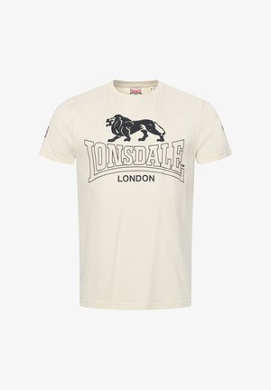 Kremo spalvos medvilninė marškinė. Su juodu liūto grafiku ir ryškiu užrašu "LONSDALE LONDON". Trumpomis rankovėmis ir apvaliu iškirpimu.