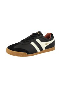 Sneakers neri con righe bianche, suola in gomma e finitura testurizzata. Accenti in suede sulla punta, con logo dorato.