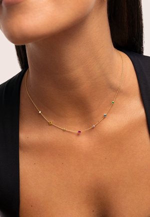 Collana in oro con sette piccole gemme colorate in diverse tonalità, disposte in un delicato schema lungo la catena.