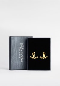 Guldörhängen med böjda mönster och sfäriska accenter, presenterade i en svart sammetfodrad box med en silverlogotyp på locket.