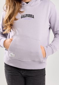Levandulová mikina s kapucí a přední kapsou, na které je černý a fialový text "CALIFORNIA" a "NATIONAL PARK, USA", žebrované manžety a lem.