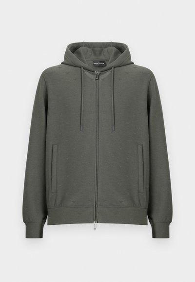 Σκούρο πράσινο φούτερ με φερμουάρ από απαλό ύφασμα, με κουκούλα, δύο πλαϊνές τσέπες και λεπτό ανάγλυφο μοτίβο σε όλη την επιφάνεια. Περιλαμβάνει φερμουάρ σε ασημί χρώμα.