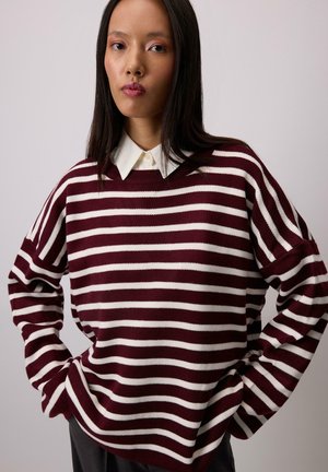 Bordeaux- og hvidstribet sweater med løstsiddende pasform, ribbet halsudskæring og lange ærmer, lagdelt over en hvid kravebluse.