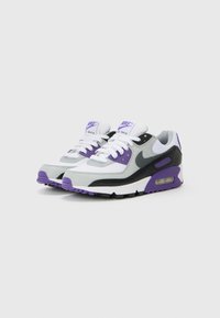 Nike Air Max tenisice imaju kombinaciju materijala u sivoj, crnoj i ljubičastoj boji s mrežastim gornjim dijelom, posebno zračnim jastučićima i bijelim vezicama.