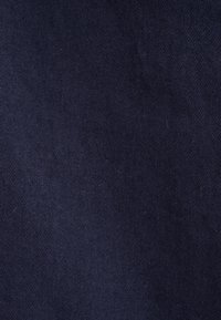 Tissu bleu marine foncé avec une texture lisse et un motif en chevron diagonal, adapté à diverses applications textiles.
