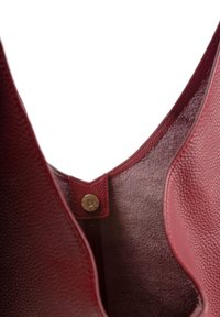 Sac à main en cuir rouge avec un extérieur texturé, intérieur non doublé et un fermoir à pression. Présente une finition douce, semblable à du daim à l'intérieur.