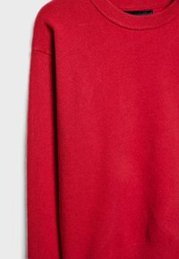 Pull en tricot rouge avec un col rond, des manches longues et une texture douce. Le tissu semble lisse avec une légère brillance.