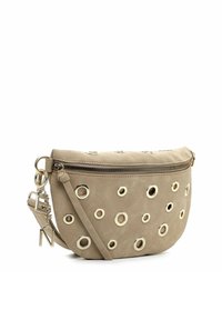 Beige suède crossbodytas met metalen oogjes als accent. Voorzien van een ritssluiting, verstelbare riem en een bedel. Ronde vorm, gladde textuur.